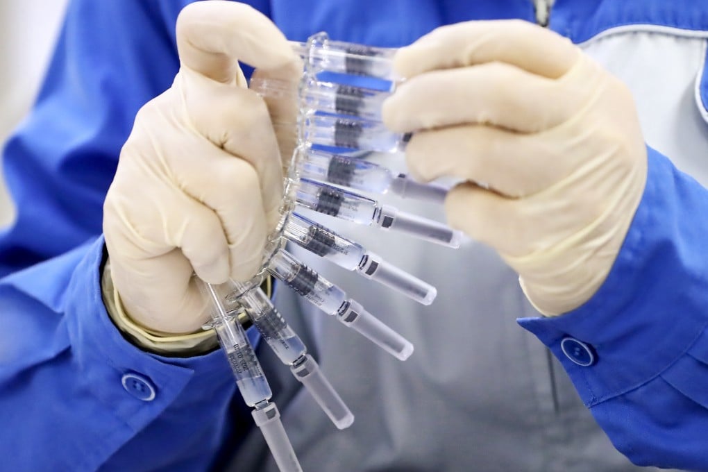 A Sinovac staff member with inactivated doses of its Covid-19 vaccine. Photo: Xinhua
