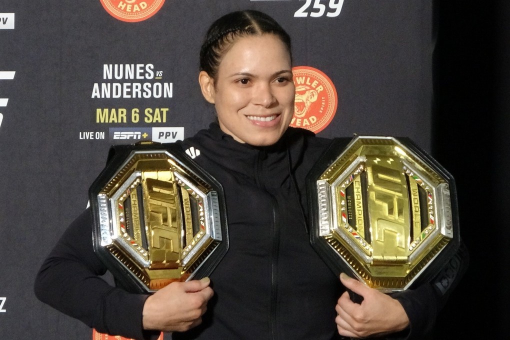 Amanda Nunes poses with her title belts after UFC 259. Photo: Drake Riggs