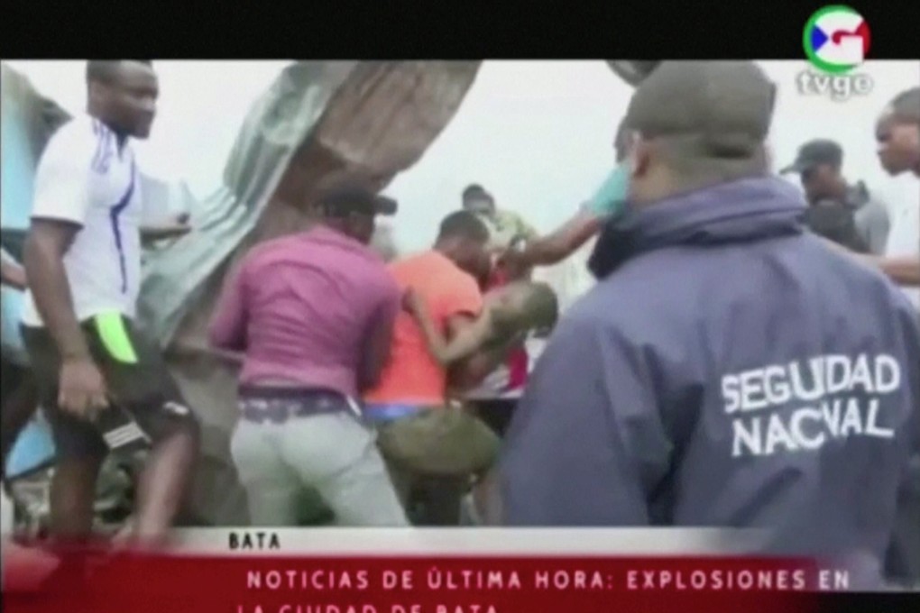 Rescuers pull a child out of rubble following explosions at a military base in Bata, Equatorial Guinea on Sunday. Photo: TVGE / Reuters