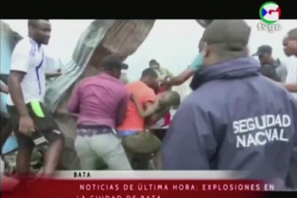 Rescuers pull a child out of rubble following explosions at a military base in Bata, Equatorial Guinea on Sunday. Photo: TVGE / Reuters