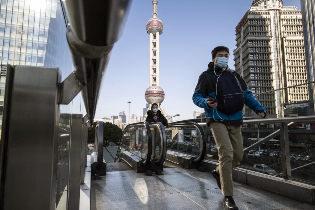 Pedestrians wearing protective masks ride on an escalator in Pudong's Lujiazui Financial District in Shanghai. Pockets of markets in mainland China and Hong Kong are in a technical bear market. Photo: Bloomberg