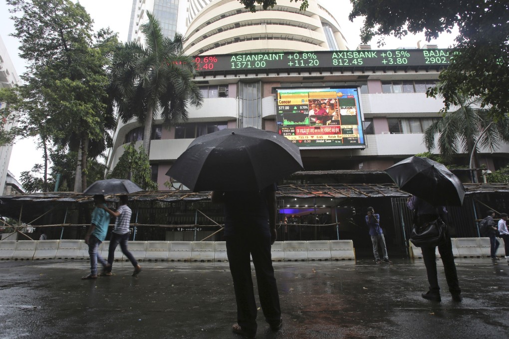 Passersby watch the stock market index on a display screen in Mumbai. Authorities are investigating a series of recent suspected cyber intrusions which could have led to a power outage in the city, crippled systems at banks and caused a glitch at a key stock exchange. Photo: AP