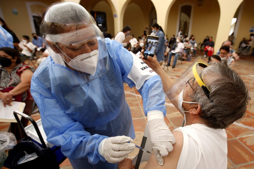 A woman takes a selfie as she gets vaccinated in Tlaquepaque, Mexico on Monday. Photo: AFP