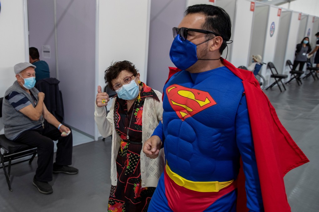 A man dressed as Superman accompanies his mother to get vaccinated in Santiago, Chile. Photo: EPA