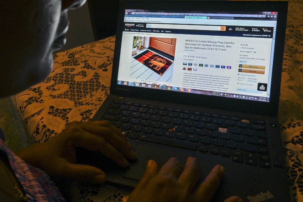 A woman views an Amazon webpage displaying Chinese-made doormats with the Sri Lankan flag design for sale in Colombo on Friday. Photo: AFP