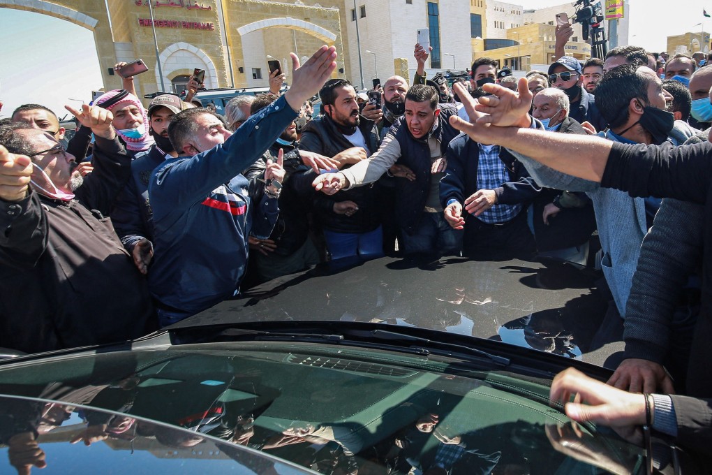Angry Jordanians stall the passage of a car of parliamentarians as it approaches a hospital in the town of Salt, Jordan on Saturday. Photo: AFP