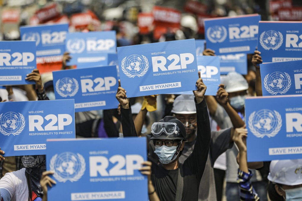 Demonstrators hold placards during a protest against the military coup, in Yangon. Photo: EPA-EFE/STRINGER