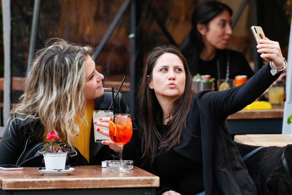 Two women in Rome take a selfie on Sunday, the last day of open restaurants and bars before tighter restrictions are enforced. Photo: Reuters