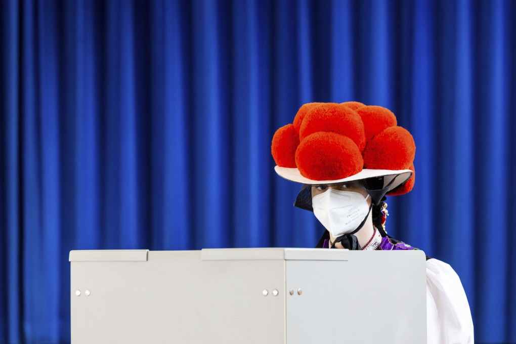 A young woman in traditional Black Forest costume casts her vote in Gutach, Germany. Photo: DPA
