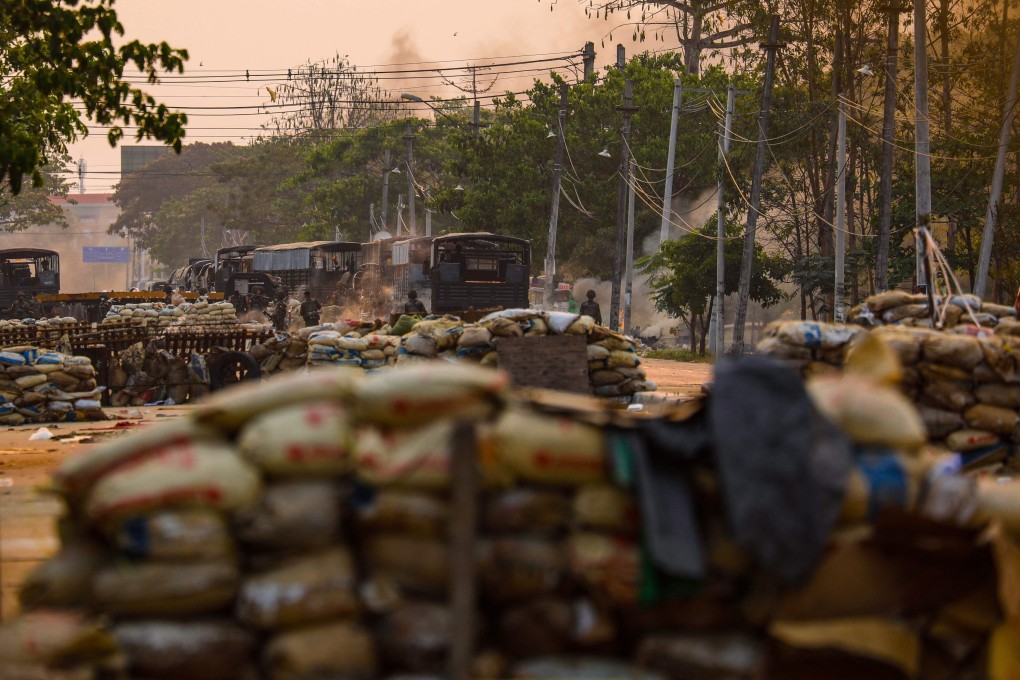 Soldiers are seen near makeshift barricades set up by protesters during a crackdown on demonstrations against the military coup in Yangon on Sunday. Photo: STR/AFP