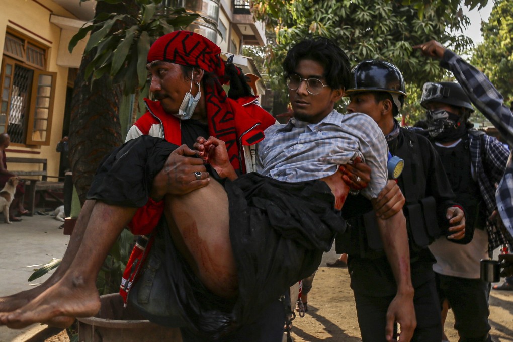 An injured demonstrator is carried to receive medical attention during an anti-coup protest in Mandalay on March 13, 2021. Photo: EPA-EFE