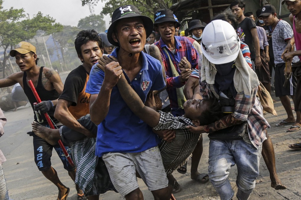 An injured demonstrator is taken for medical attention during a protest against the military coup in Hlaing Tharyar district of Yangon. Photo: EPA-EFE