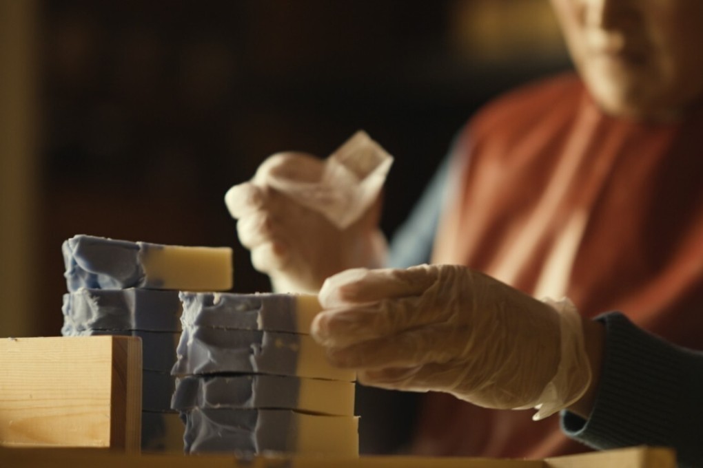 A worker at Kadhak Organics stamps soap bars with the company’s logo. Photo: Guo Yong