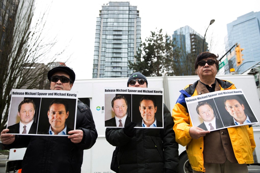 Protesters hold photos of Canadians Michael Spavor and Michael Kovrig, who are being detained by China, outside the British Columbia Supreme Court in Vancouver in March 2019. Photo: AFP
