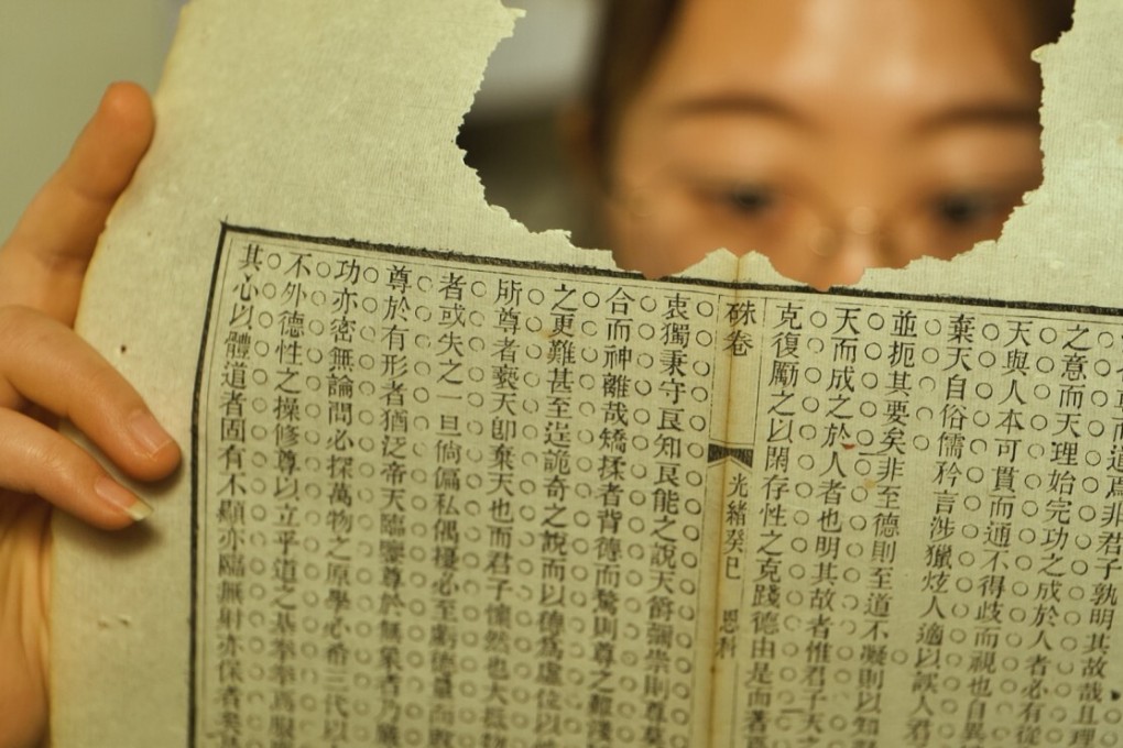 Lian Chengchun examines a torn page at her studio in Beijing. Photo: Patrick Wong