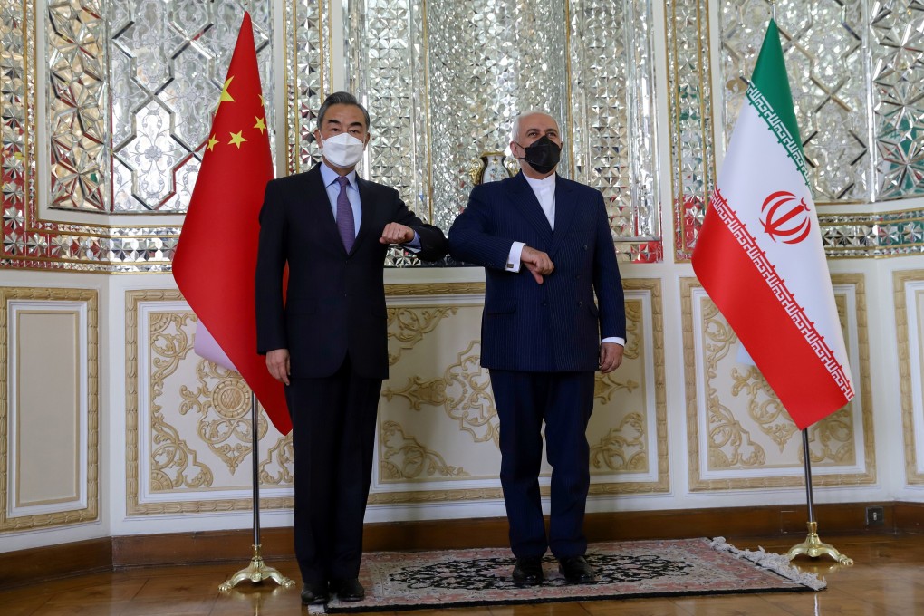 China's Foreign Minister Wang Yi bumps elbows with his Iranian counterpart Mohammad Javad Zarif. Photo: Reuters