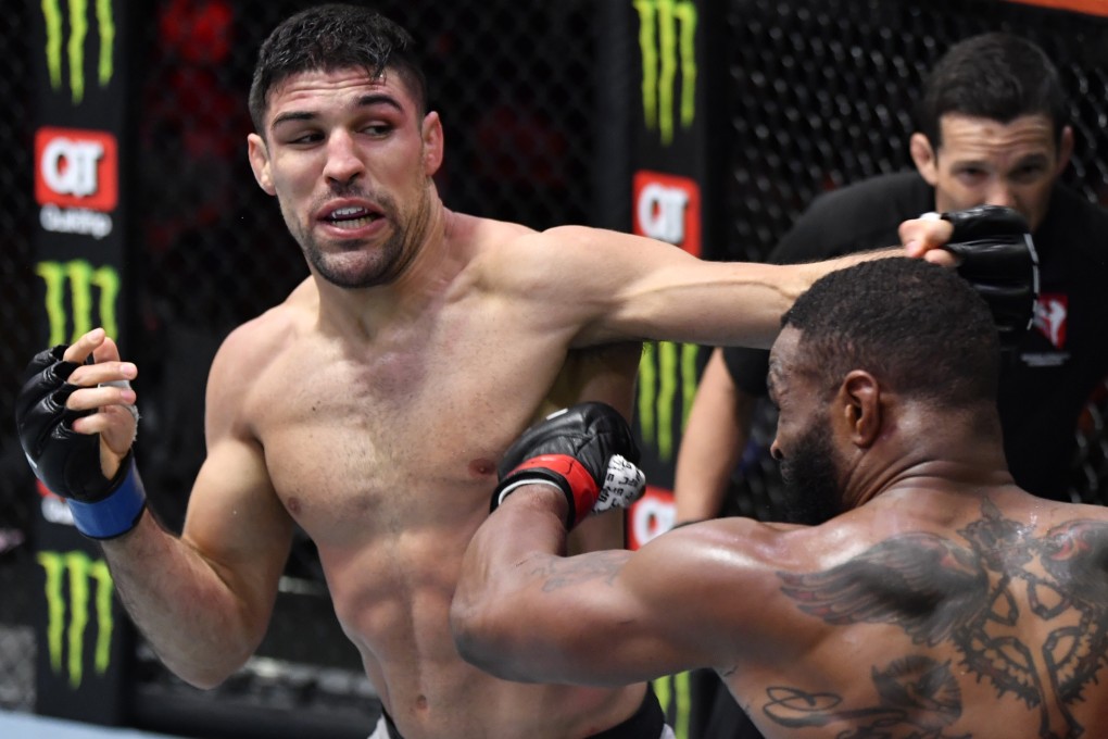 Vicente Luque punches Tyron Woodley in their welterweight fight at UFC 260. Photos: Jeff Bottari/Zuffa LLC