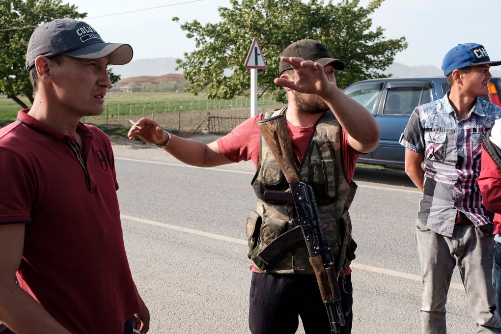 Men from the village of Kyzyl-Bel keep watch on a road in Kyrgyzstan’s Batken region. Photo: AFP