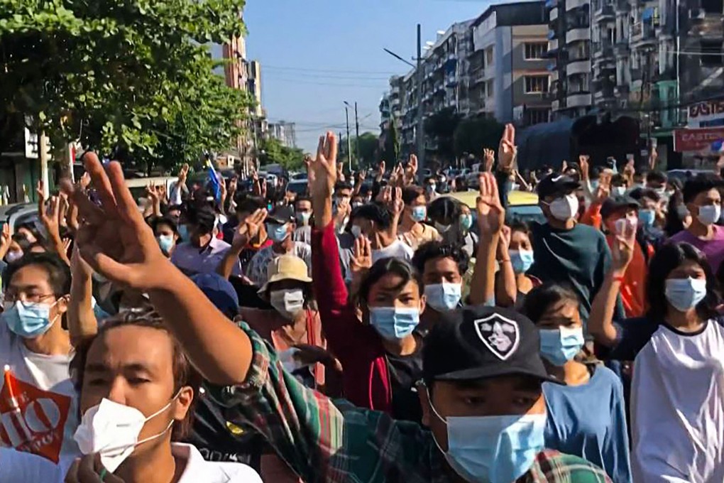 Protesters flash the three-finger salute during an anti-coup rally in Yangon on Sunday. Photo: AFP