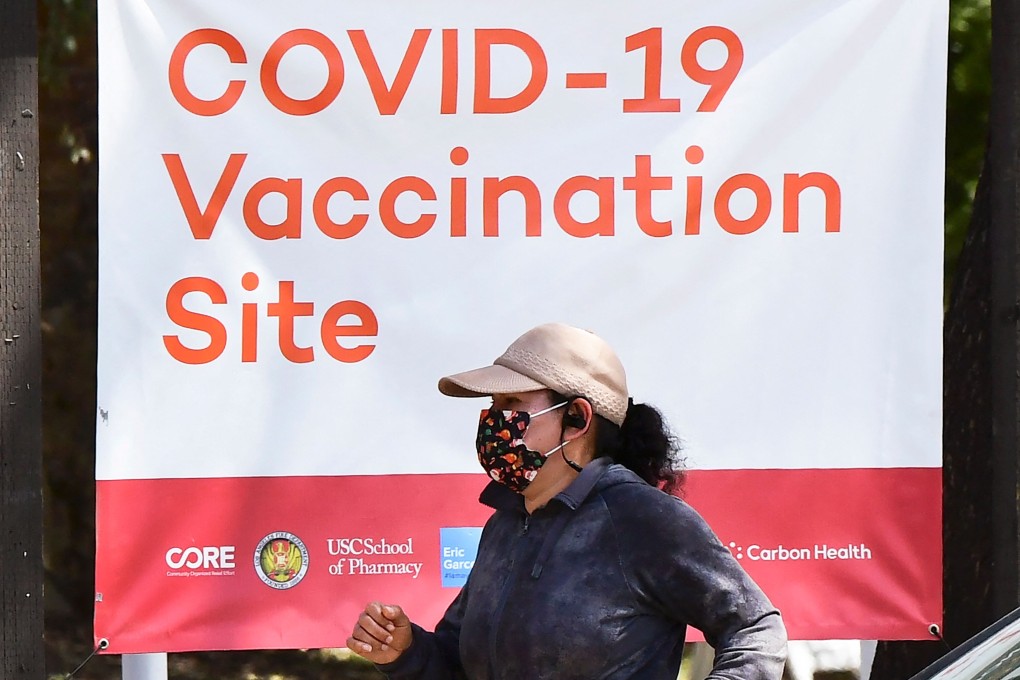 A woman walks past a Covid-19 vaccine site in Los Angeles, California. Photo: AFP
