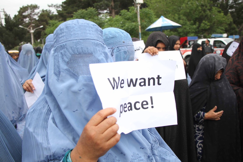 Afghan people hold posters calling for peace during a protest on Sunday in Herat to condemn violence, which has surged in Afghanistan since a missed May 1 deadline for US troops to withdraw. Photo: EPA