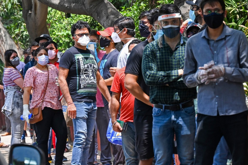 People queue outside a vaccination centre in New Delhi as India tries to contain its surging coronavirus crisis, while Australians in the country are unable to return home. Photo: AFP