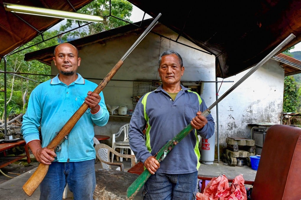 Indigenous hunter Tama Talum (right) and his neighbour pose with their guns at a village in Taitung county. Photo: AFP