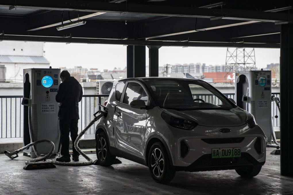 A man charges his electric car in Beijing. Photo: Bloomberg