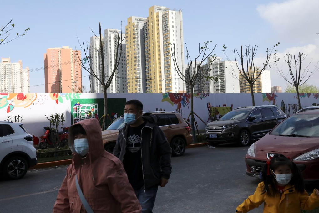 People walk past residential buildings in Beijing, China, on April 16, 2021. Photo: Reuters