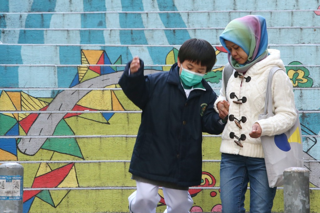 A domestic helper walks with a child in her care in February 2018. Given the limited care options for children in Hong Kong, many families rely on migrant workers to help look after their children at home. Photo: David Wong