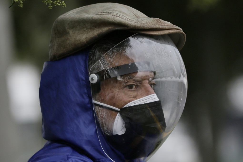 A man wearing a full protective face shield and double mask waits to be vaccinated in Quito, Ecuador. Photo: AP