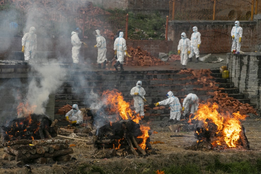 Workers in protective suits cremate the bodies of Covid-19 victims while others extend the crematorium on Wednesday as the number of deaths rise near Pashupatinath temple in Kathmandu, Nepal. Photo: AP
