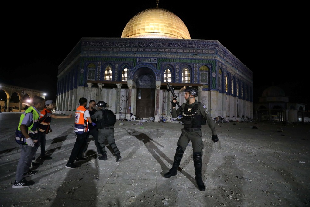 An Israeli policeman scuffles with a Palestinian during clashes at a holy site in Jerusalem on Friday. Photo: Reuters