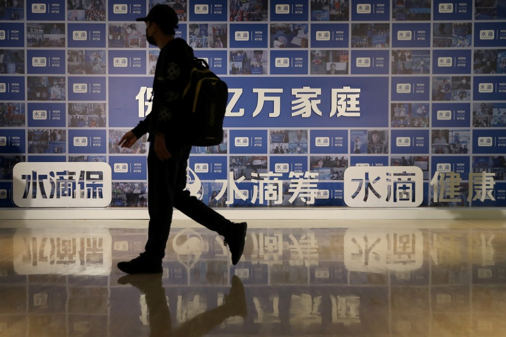 A man walks past a billboard with signs of Tencent Holdings-backed Waterdrop in Beijing, ahead of the Chinese online insurance technology firm’s initial public offering at the New York Stock Exchange on May 7, 2021. Photo: Reuters