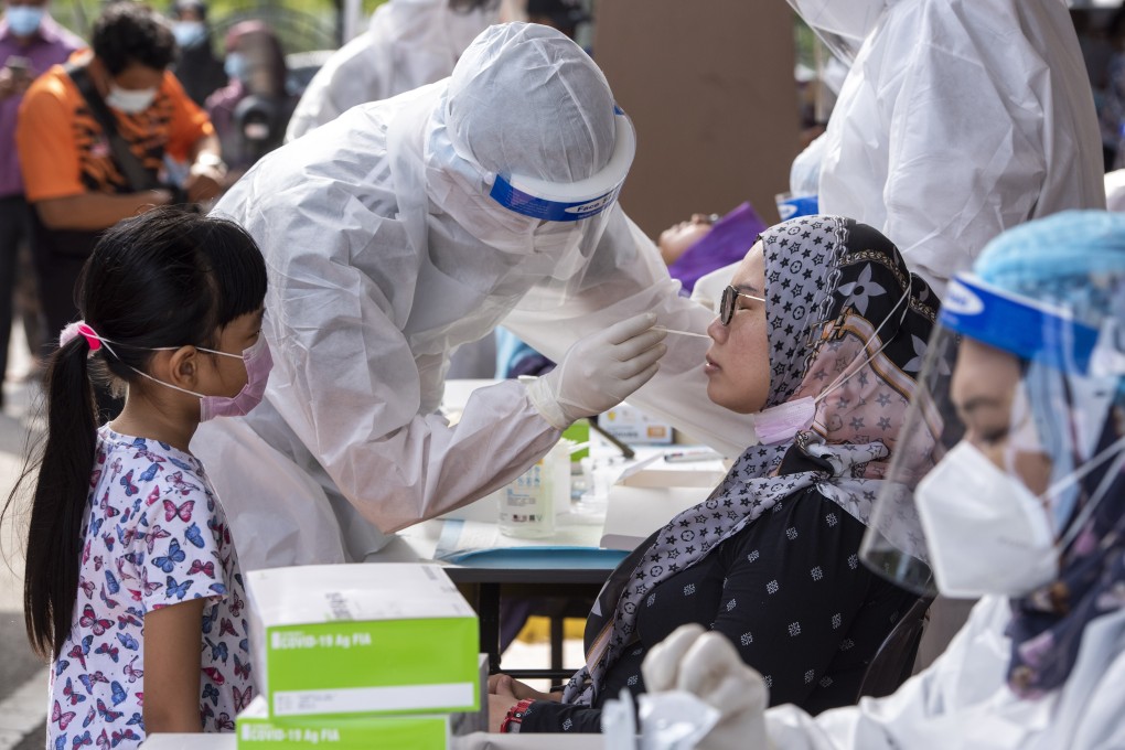 A medical worker takes a swab sample from a woman in Kajang, Malaysia, to test for Covid-19. Photo: Xinhua