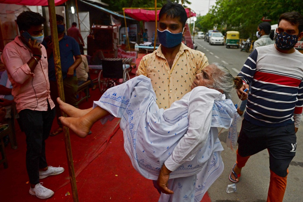 A family member carries a patient who is having difficulty breathing to a free oxygen support centre on the outskirts of New Delhi on Monday, amid India’s raging Covid-19 pandemic. Photo: AFP