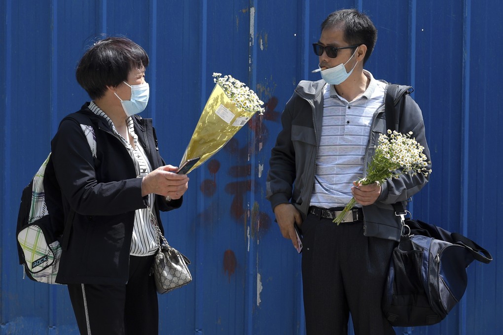 Chen Mei’s mother (left) and Cai Wei’s father with flowers given to them by the defendants’ supporters. Photo: AP