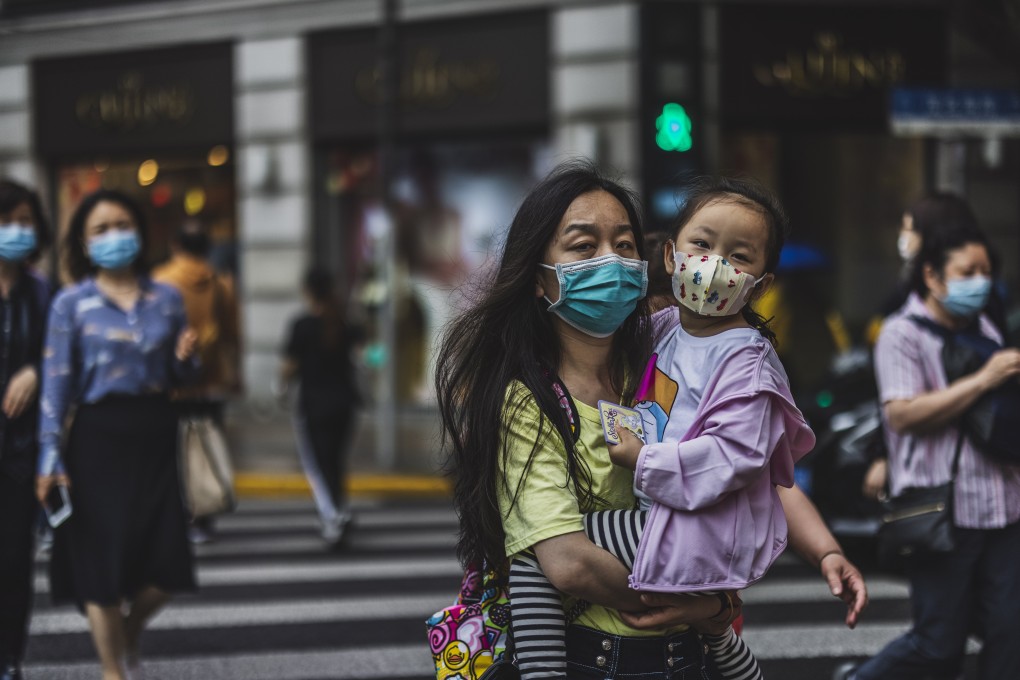 People cross the street in Shanghai on May 11. China must make a whole-of-society push to raise the birth rate, and this must include making childcare more accessible to working families. Photo: EPA-EFE