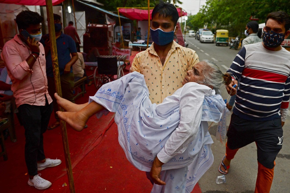 A man takes a family member to a free oxygen support centre being run by a Gurdwara, a place of worship for Sikhs, on the outskirts of New Delhi. Photo: AFP