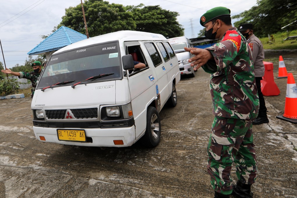 Security officers stop a minivan at a checkpoint in Indonesia after the government imposed a travel ban earlier this month ahead of the Eid-ul-Fitr festival. Photo: EPA
