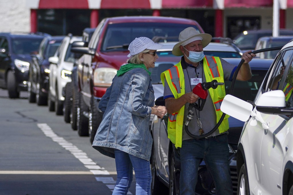 A customer gets help filling up on petrol at a Costco in Charlotte, North Carolina, as other wait in line on Tuesday. Photo: AP