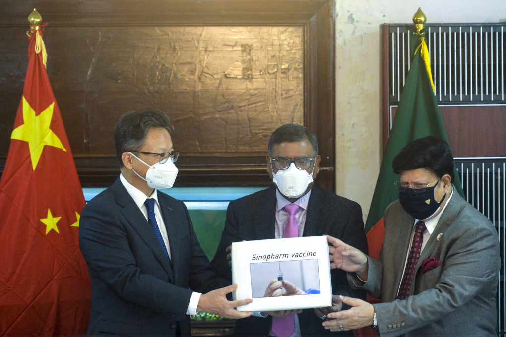 Ambassador Li Jiming (left) presents 500,000 Chinese-made Covid-19 vaccine doses to Bangladeshi Foreign Minister A.K. Abdul Momen (right) and Health Minister Zahid Maleque on Wednesday. Photo: AFP