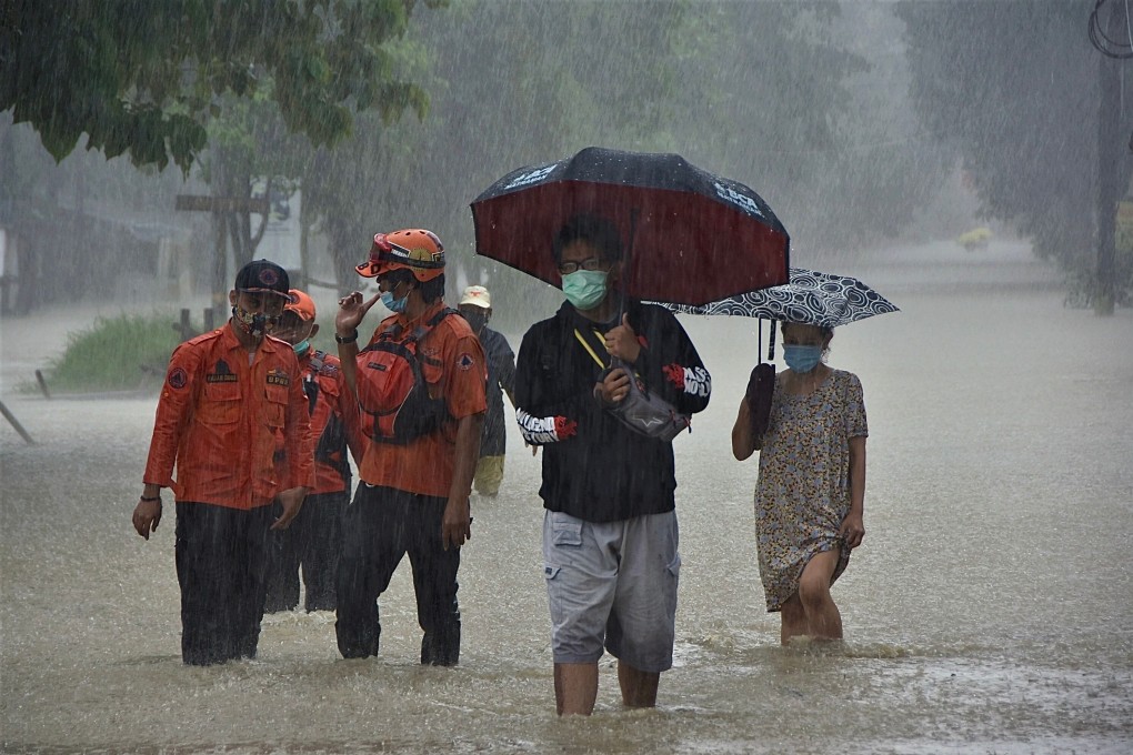 Residents walk along a flooded street on the outskirts of Jakarta in February. The Indonesian capital topped the list of combined risk based on all nine factors analysed. Photo: AFP