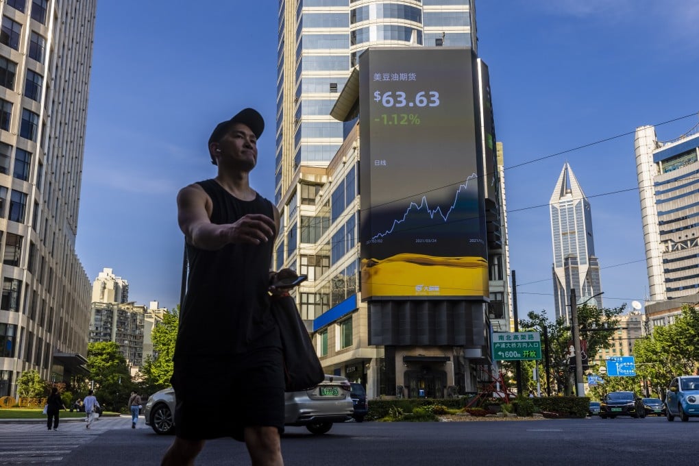 A man passes under the large screen showing the latest stock market data in Shanghai on May 10. Photo: EPA-EFE