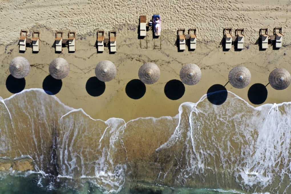 A woman enjoys the sun at Plaka beach on the Aegean island of Naxos, Greece. Photo: AP