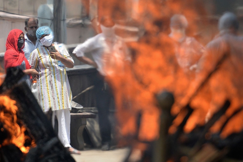 Relatives and family members perform the last rites of the patients who died of Covid-19 at a crematorium in New Delhi on Saturday. Photo: AFP