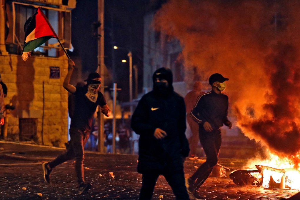 Palestinian protesters hurl stones during clashes with Israeli forces in the Palestinian neighbourhood of Shuafat, neighbouring the Israeli settlement of Ramat Shlomo, in Israeli-annexed east Jerusalem. Photo: AFP
