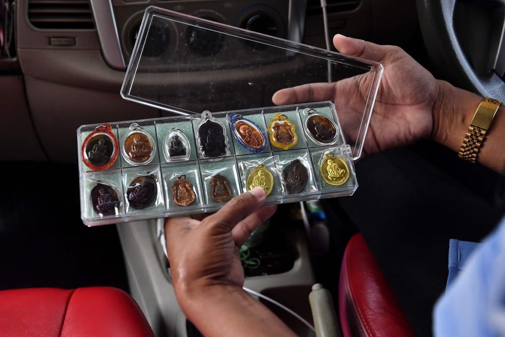Taxi driver Wasan Sukjit shows off his protective Buddhist amulets. Photo: AFP