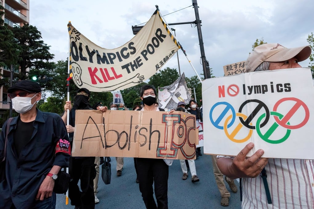 Opposition to the Tokyo Games is becoming more fervent in the host nation as protesters hold up signs while marching in front of Tokyo’s National Stadium. Photo: DPA