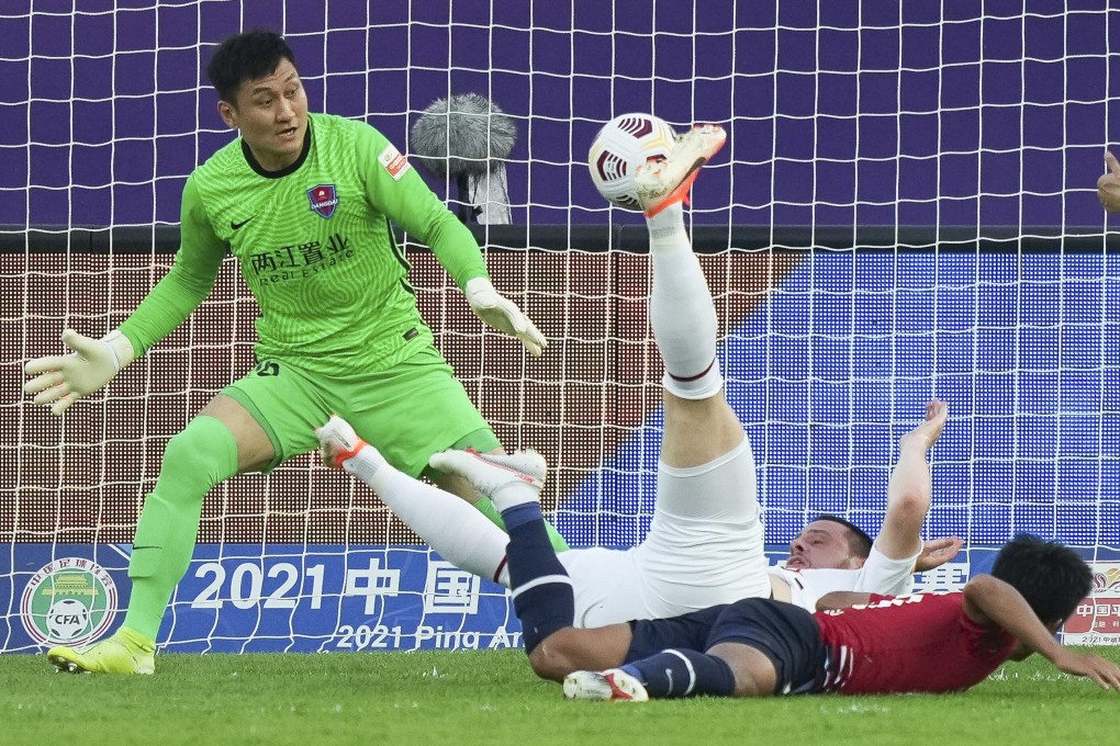 Qingdao FC’s Radonjic (centre) goes down under a strong challenge during the match against Chongqing. Photo: Xinhua
